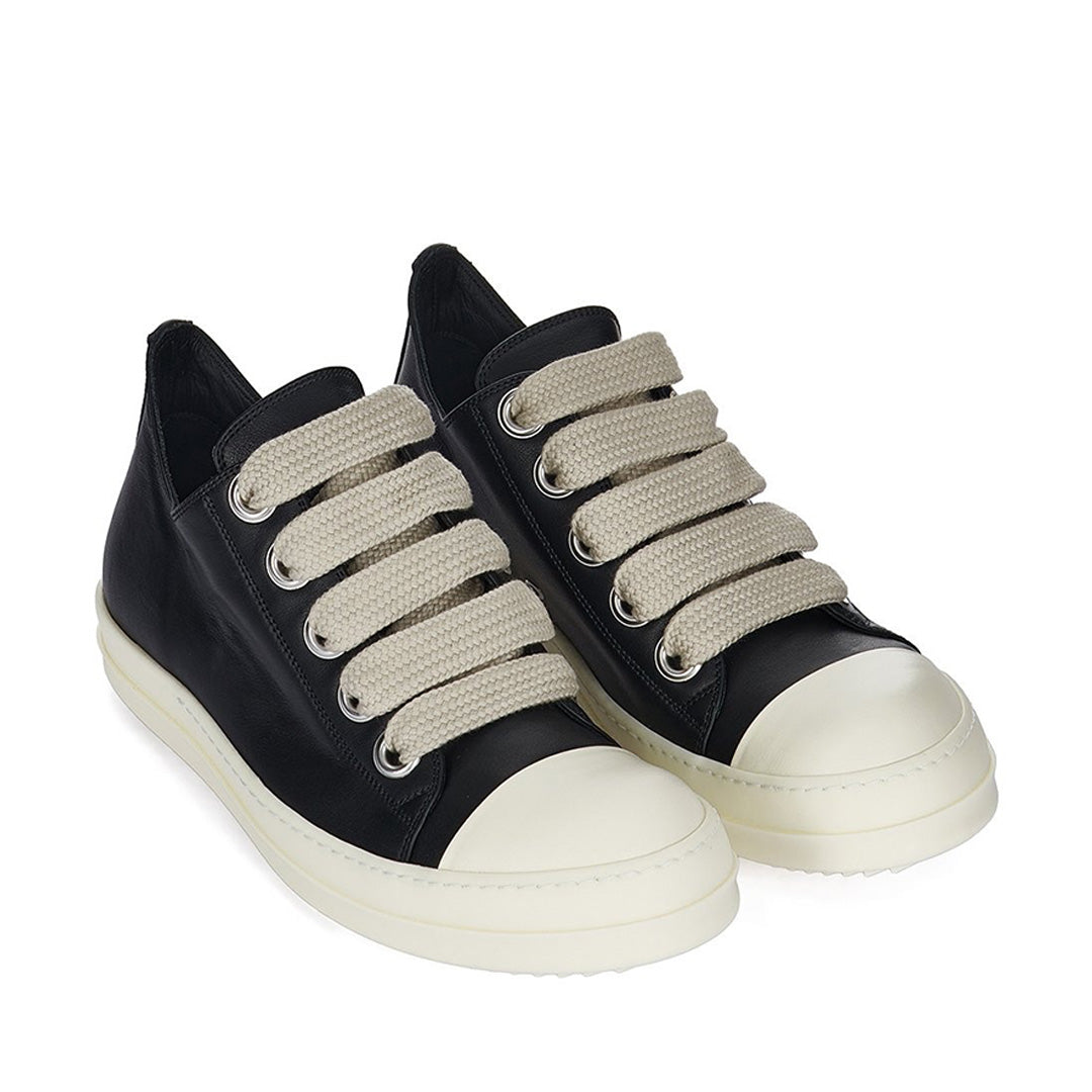 Black sneakers with beige laces on a white background